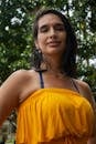 Smiling woman in yellow dress enjoying a sunny day outdoors in Mérida, Venezuela.